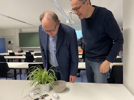 Professoren betrachten den intelligenten Blumentopf